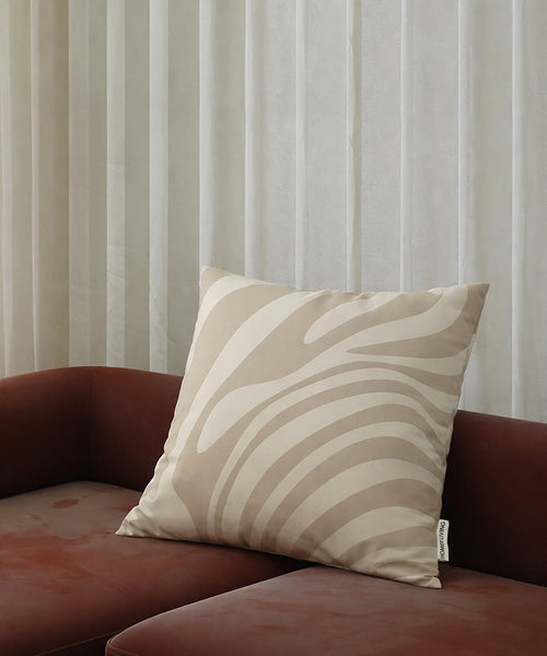 Poszewka dekoracyjna Beige (zebra)© HOMIES LIVING w beżowy wzór zebry na bordowej sofie